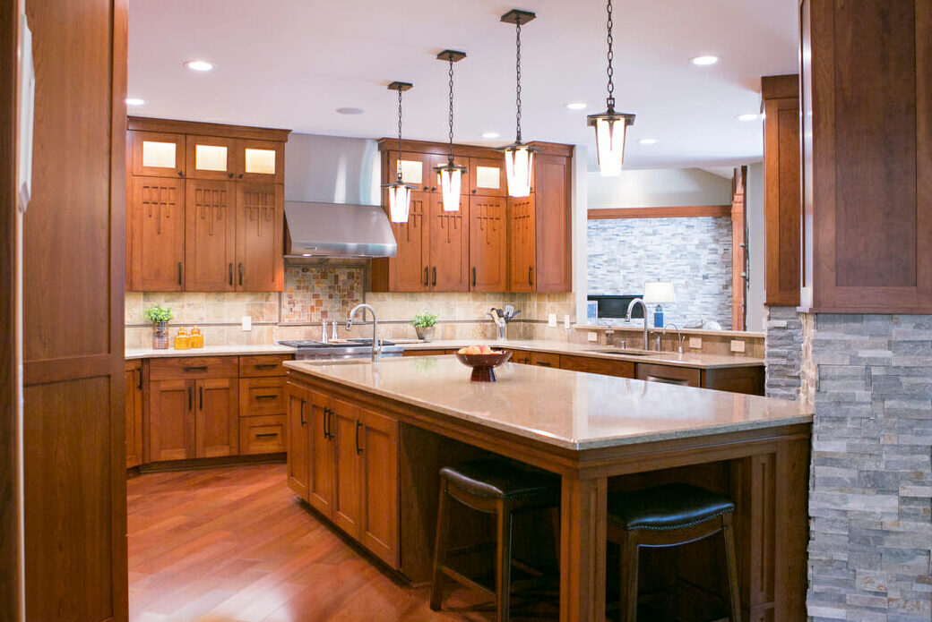 Modern kitchen featuring wooden cabinets, a large island with seating, and pendant lighting over a granite countertop.