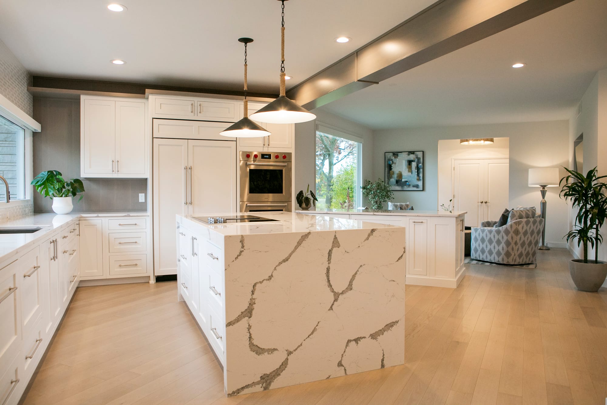 A stunning kitchen remodel in Madison, WI, featuring a spacious marble waterfall island, sleek white cabinetry, and high-end stainless steel appliances. Designed by expert interior designers in Madison, this modern kitchen renovation blends functionality with contemporary elegance. Ideal for homeowners seeking high-end home remodeling contractors in Madison, WI.