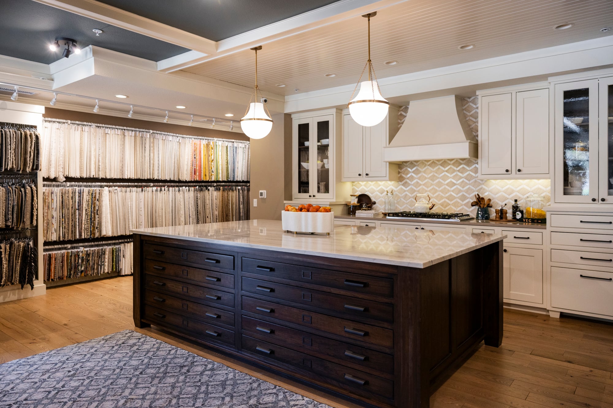 Kitchen with fabric swatch display, island, and white cabinets.