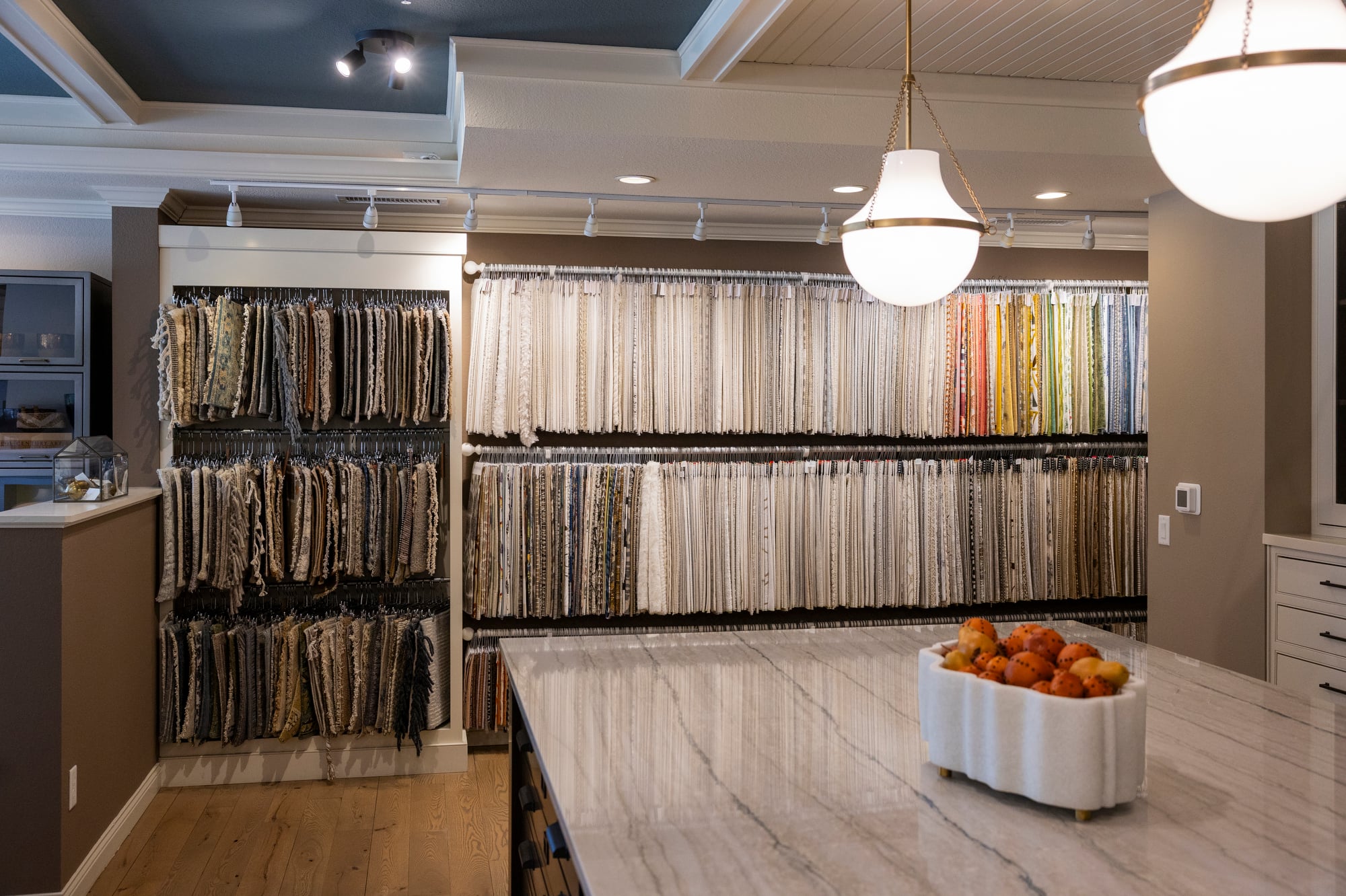 Fabric swatch display with marble countertop and decorative pumpkins.