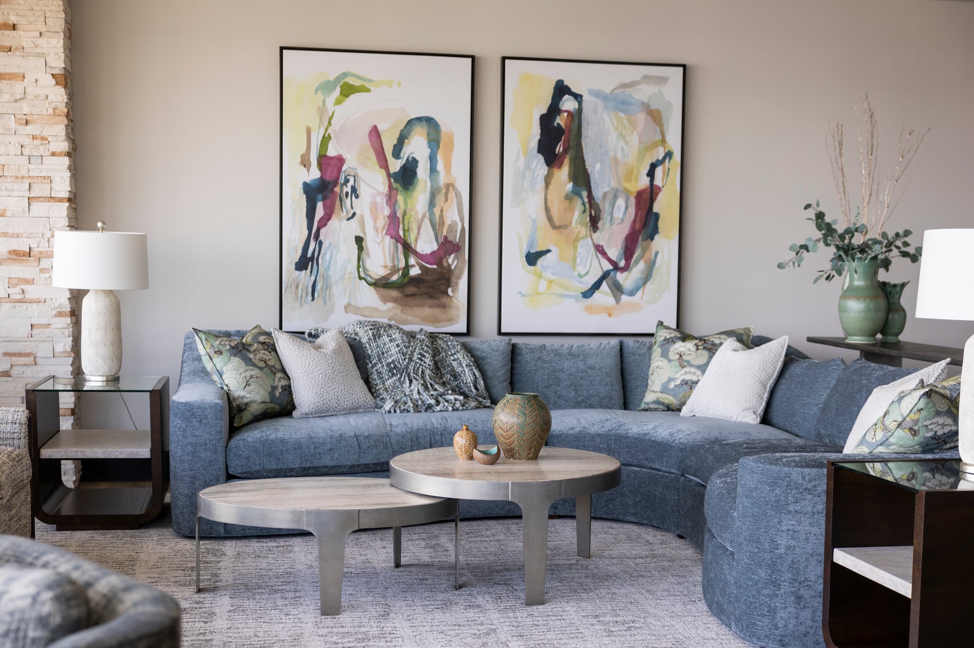 Blue sectional sofa with abstract art and decorative pillows.