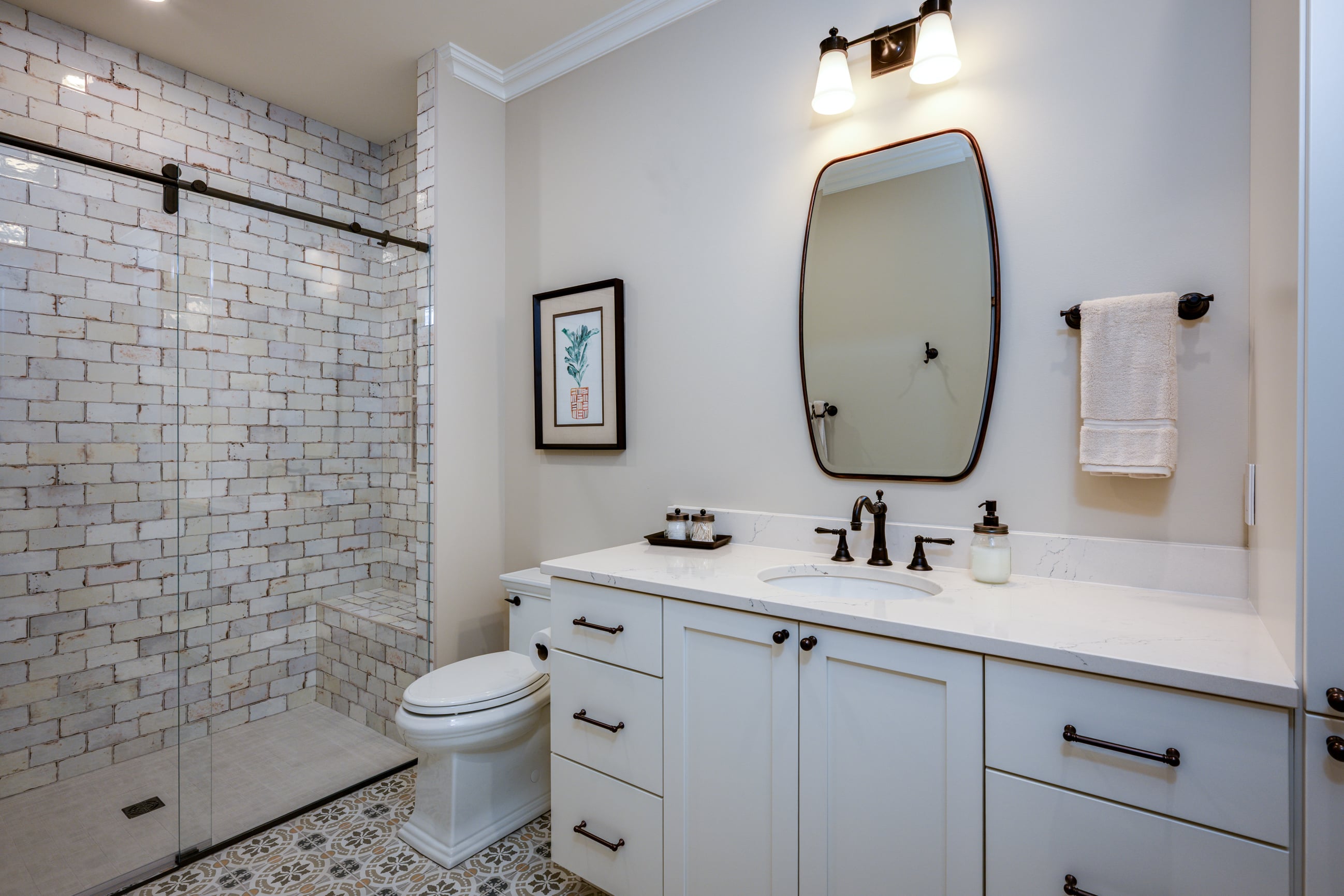 Modern bathroom with white brick shower, vanity, and toilet.