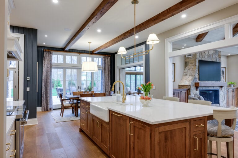 Kitchen island with white countertop, farmhouse sink, and wood cabinets.