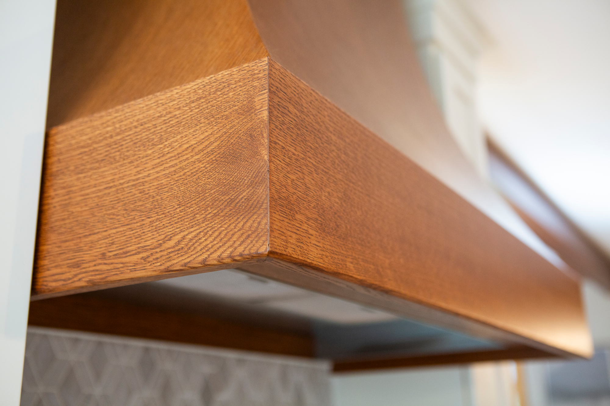 Wooden range hood with visible grain, showing a corner detail.