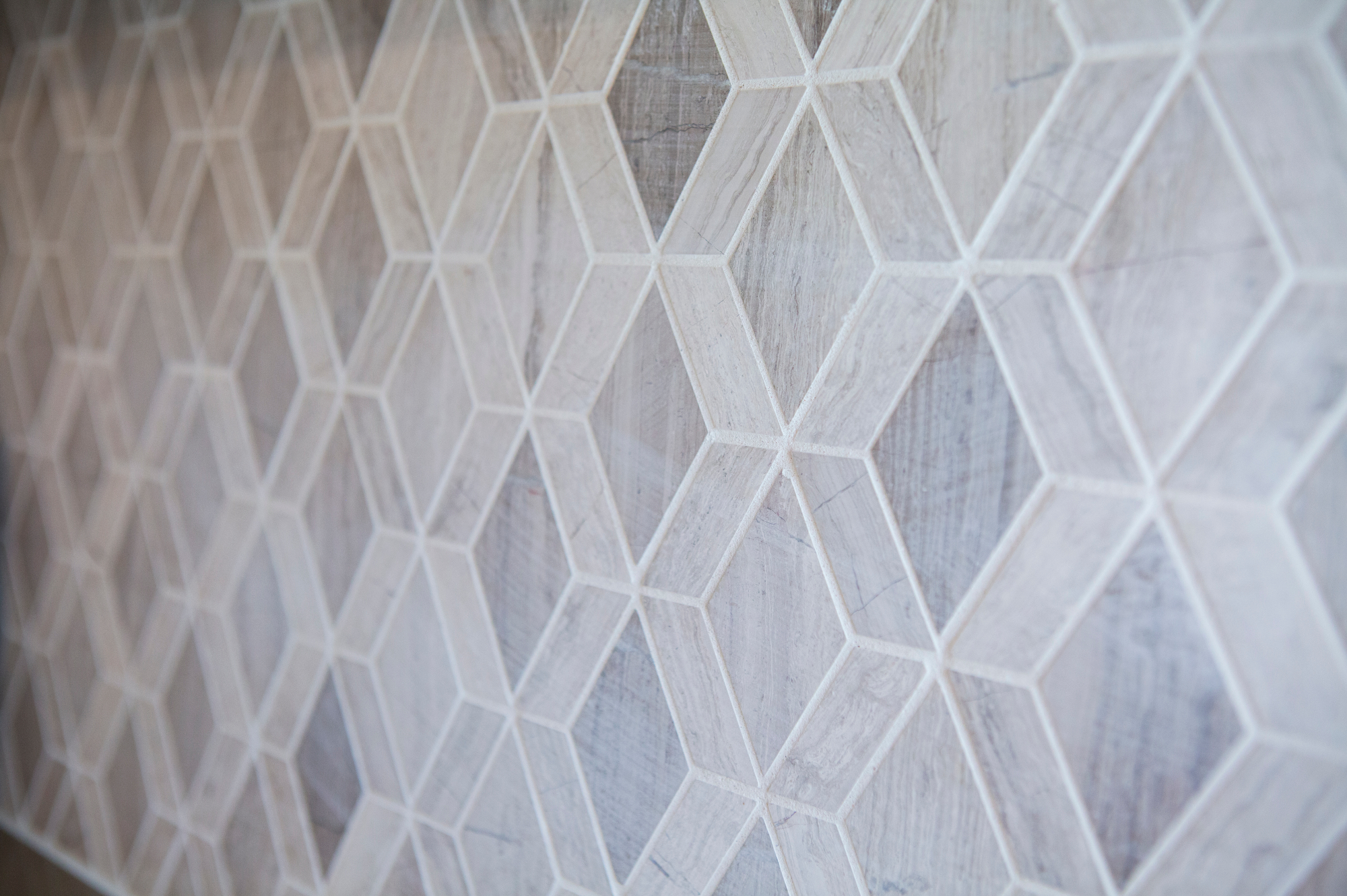 Geometric diamond pattern tiles with a wood-grain texture.