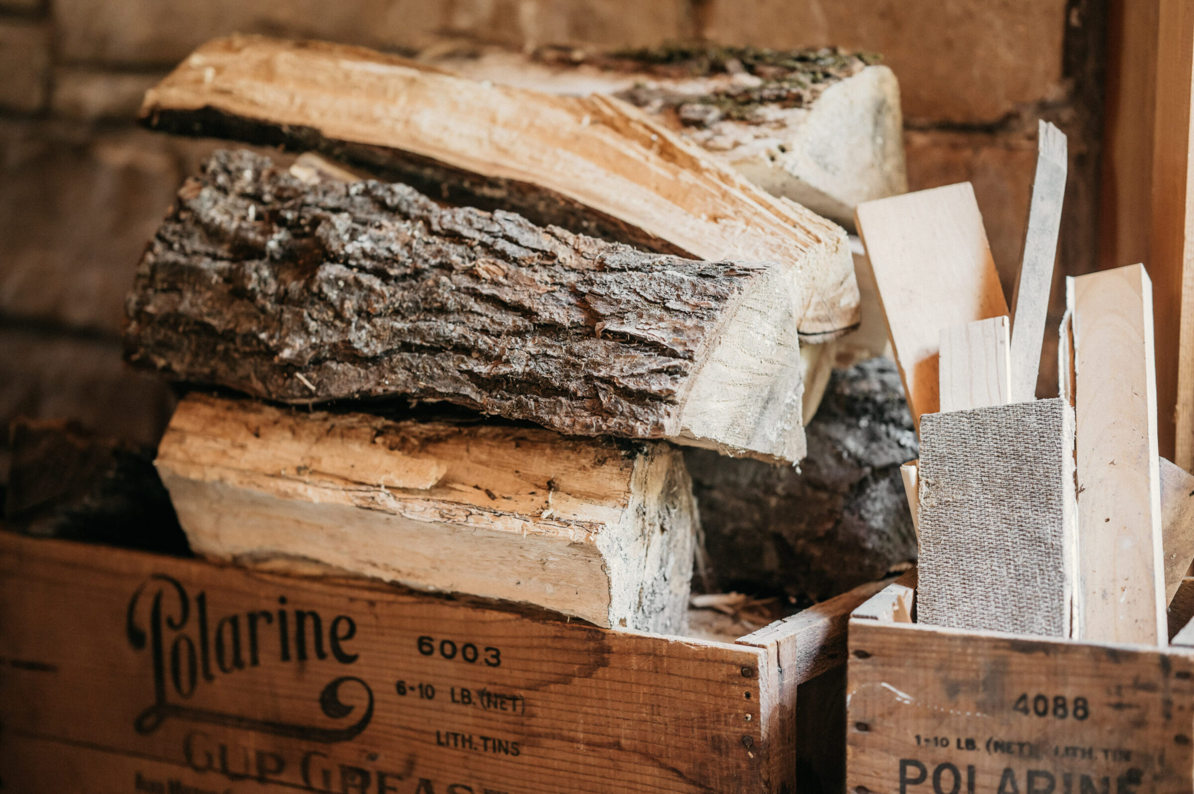 Stack of firewood in wooden crates, with some smaller wood scraps.