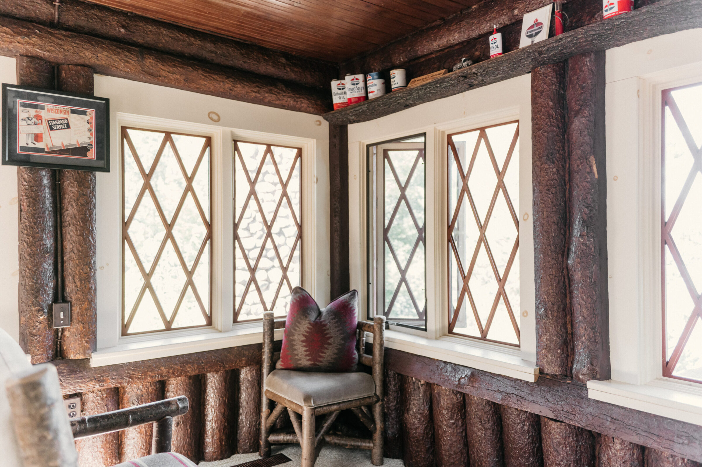 Log cabin interior with diamond pane windows and vintage cans on shelf.